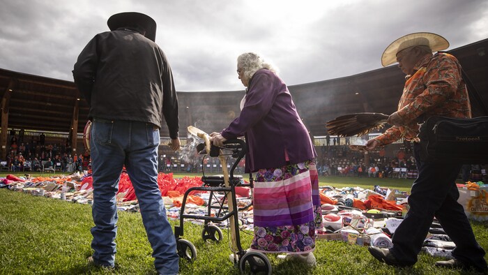 David Archie smudges donations that have been gathered in an arbour on Monday to mark one year since the Tk̓emlúps te Secwépemc First Nation announced the discovery of potential burial sites at the former Kamloops Indian Residential School. A series of ceremonies are planned through the day.