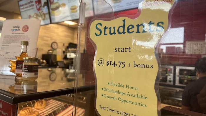 Une annonce de Tim Hortons qui dit que des étudiants peuvent commencer avec un salaire de 14 dollars 75 sous l'heure. Ils peuvent également recevoir des bonis et d'autres avantages. 
