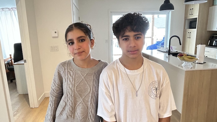 Deux adolescents dans une cuisine.