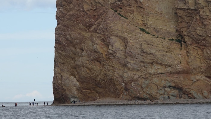Des touristes qui s'approchent du rocher percé