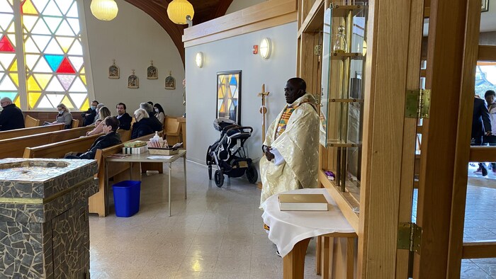 Le prêtre se prépare à traverser la salle et célébrer la messe. 