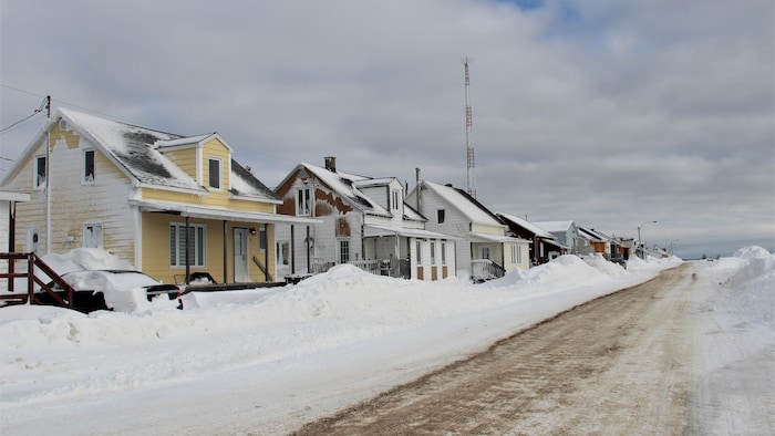 Des maisons le long d'une rue enneigée.