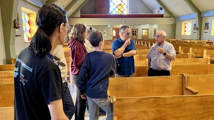 A family that participates in the guided tour listens to the guide in a church. aboriginal tourism: pessamit invests $
