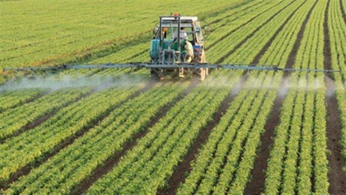 Un tracteur répand des pesticides.