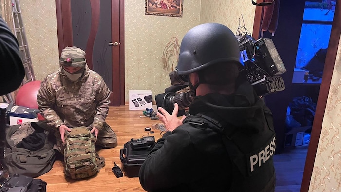 Un caméraman prend des images d'un soldat qui prépare son sac.