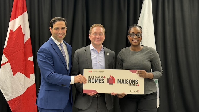 Le député fédéral Peter Fragiskatos, le maire de London, Josh Morgan, et la députée fédérale de London-Ouest, Arielle Kayabaga, tiennent une affiche « Maisons Canada » lors de la conférence de presse.
