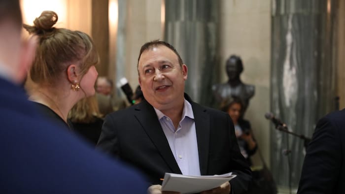 Peter Gilmer parle avec une dame au Palais législatif.
