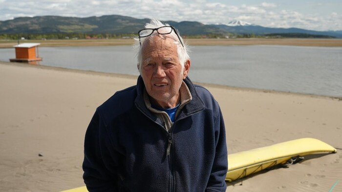 Un homme se tient sur une plage, sur les berges du lac Marsh, au Yukon.