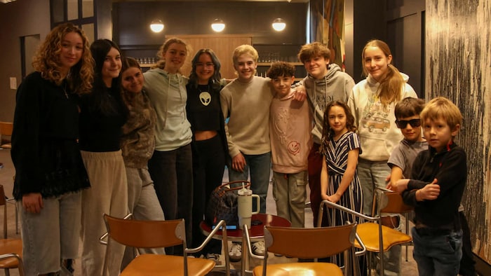 Douze enfants, âgé entre 6 et 17 ans, font la pose pour la caméra.
