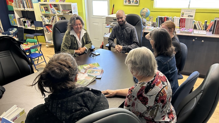 Des personnes assises à une table.