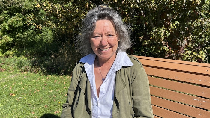 Une femme assise sur un banc dans un parc.