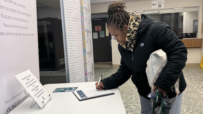 Une femme signe la pétition.