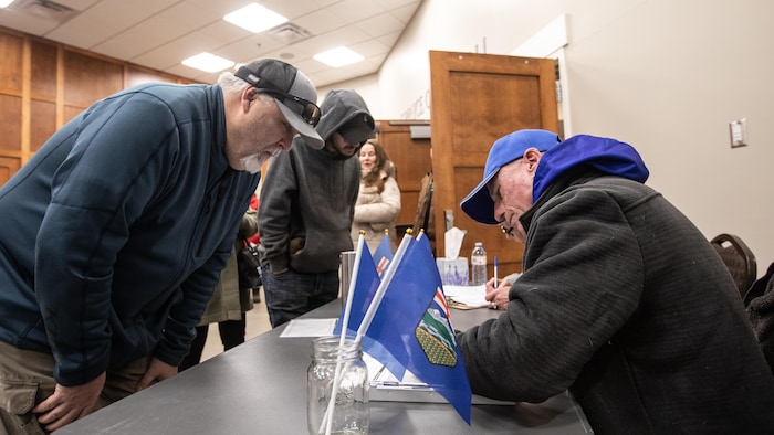 Des personnes participent à une collecte de signatures.
