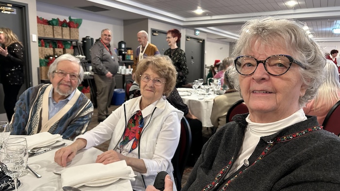 Des participants assis à une table sourient.