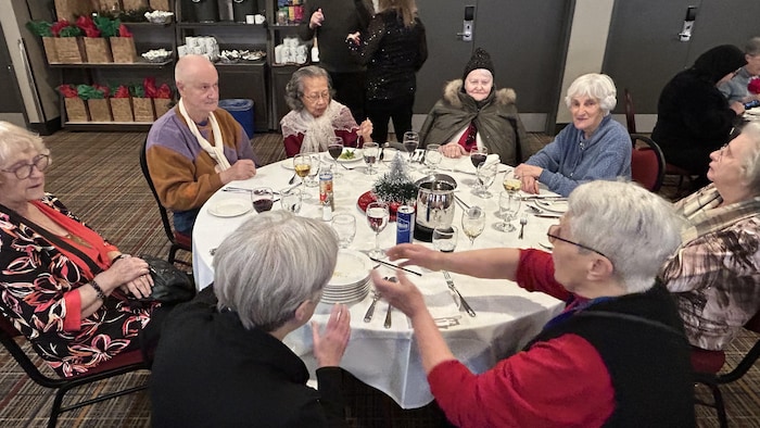 Des personnes aînées assises à une table festive.