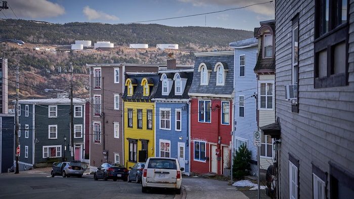 Des maisons en rangée sur une rue descendante.