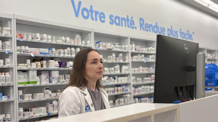 Julie Jean pose derrière le comptoir de sa pharmacie.