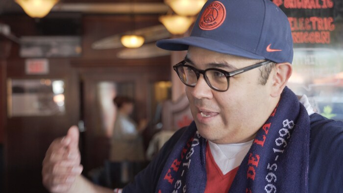 Un homme avec une casquette du PSG.