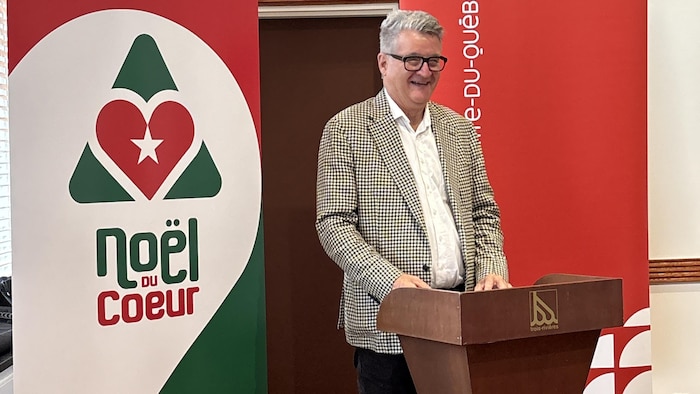 Philippe Duguay devant les bannières du Noël du cœur.