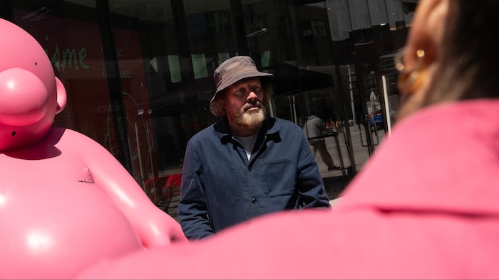 Philippe Katerine est face à la caméra. Derrière lui, on voit une de ses sculptures roses.