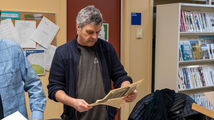 Philippe Marquis regarde un article de journal.