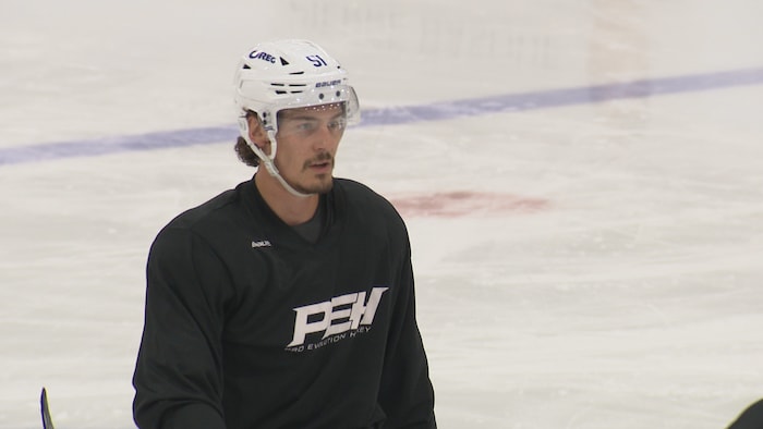 Philippe Myers sur la glace aborde un chandail Pro Evolution Hockey.