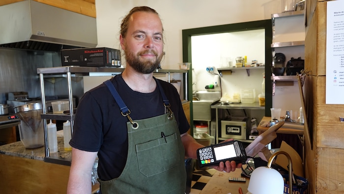 Le chef et copropriétaire de Chez Renard, Philippe Raymond, photographié avec un terminal dans son restaurant.