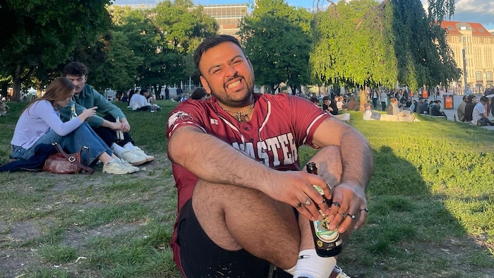 Pheonyx Ahmed sourit dans un parc berlinois, avec la Tour de la télévision de Berlin en arrière-plan en 2025.