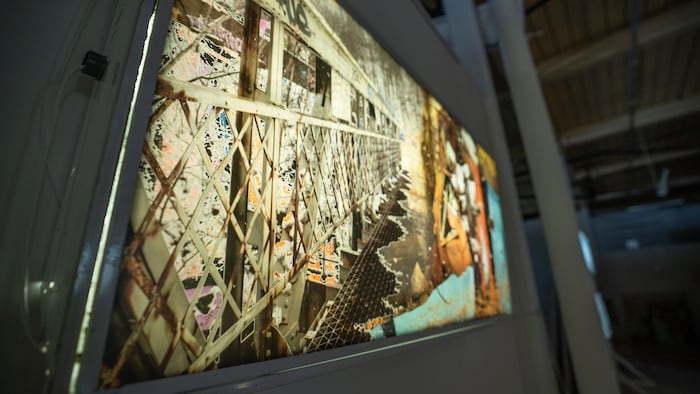 Une photographie rétroéclairée installée sur un cadre d’aluminium dans une exposition.