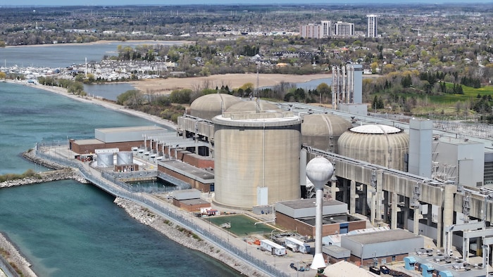 La centrale nucléaire de Pickering au premier plan, en arrière-plan on voit des quartiers résidentiels et des lieux naturels.