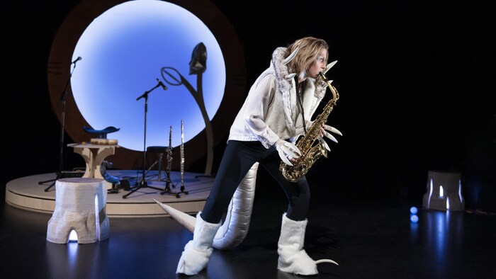 Une personne joue du saxophone sur scène.