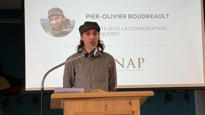 Pier-Olivier Boudreau debout sur une scène pour parler à son auditoire.