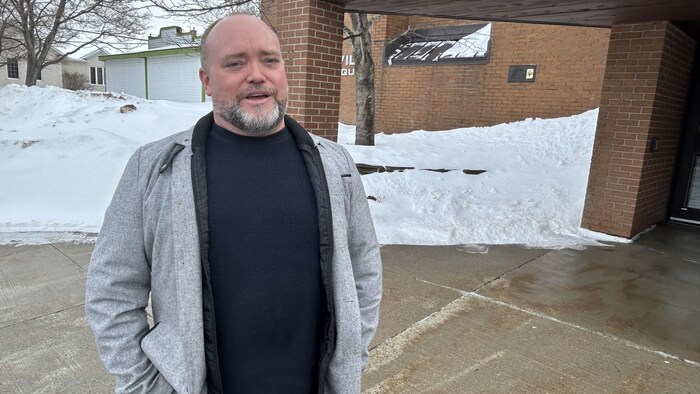 Pierre Boudreau sourit à l'objectif, devant l'hôtel de ville.