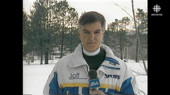 Plan buste de Pierre Dufault qui anime l'émission dehors, l'hiver. Il porte un manteau de sport.