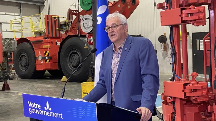 Pierre Dufour debout derrière un pupitre s'adresse à son auditoire.