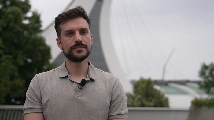 Un chargé de projet du Parc olympique en entrevue devant la tour du stade.