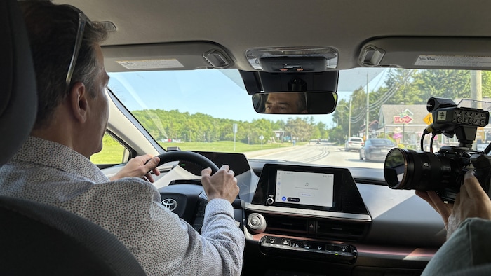 Pierre Guénard conduit une voiture. Une caméra le filme.