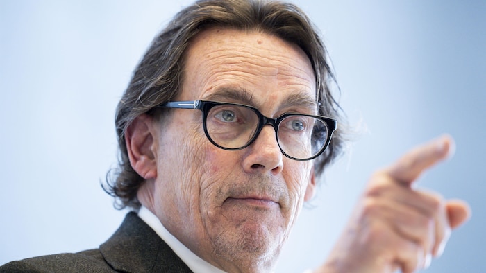 Pierre Karl Péladeau l'air sérieux, portant des lunettes, pointe son doigt. 