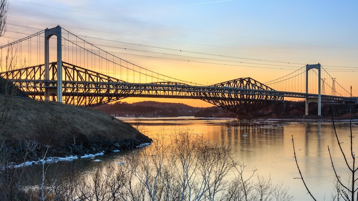 Les ponts Pierre-Laporte et de Québec photographiés depuis la rive nord du fleuve Saint-Laurent lors d'un coucher de soleil.