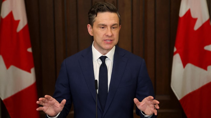 Pierre Poilievre parle devant un micro.