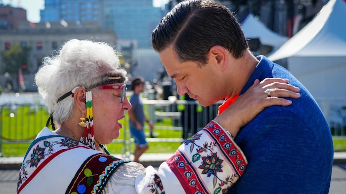 Une aînée inuk pose sa main sur l'épaule de Pierre Poilievre.