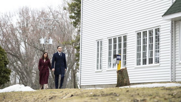 Le couple marche près d'une maison en se tenant par la main.