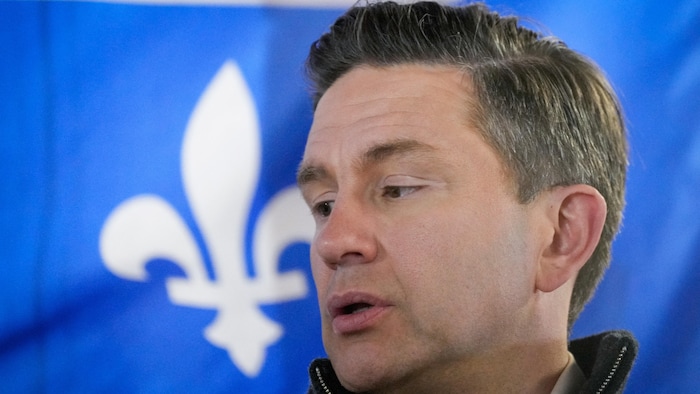 Pierre Poilievre devant un drapeau du Québec.
