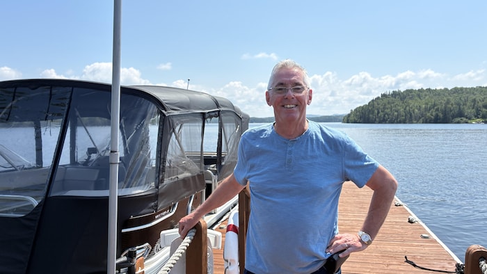 Un homme prend la pose devant son ponton.