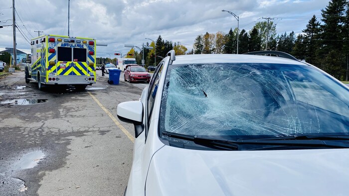 Un véhicule avec le pare-brise éclaté est placé devant une ambulance. 