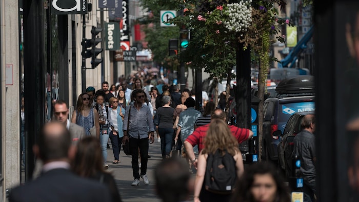 Des piétons déambulant sur la rue Sainte-Catherine, à Montréal, en été.