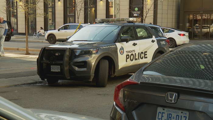 Une voiture de police stationnée au bas d'un immeuble.