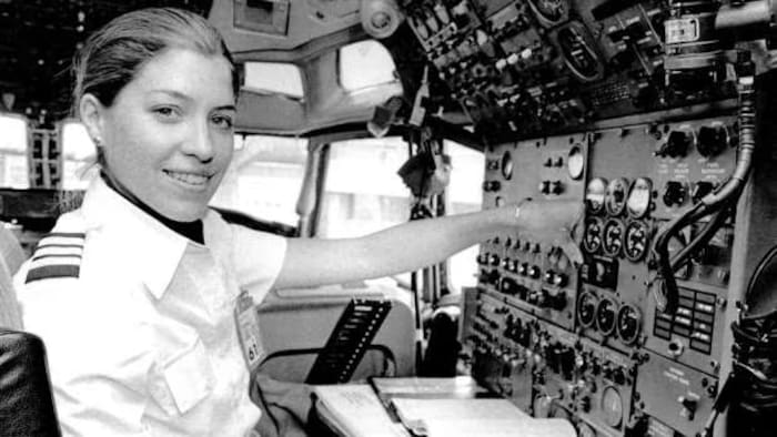 In this black and white photo, Jodi Cameron sits on a plane.