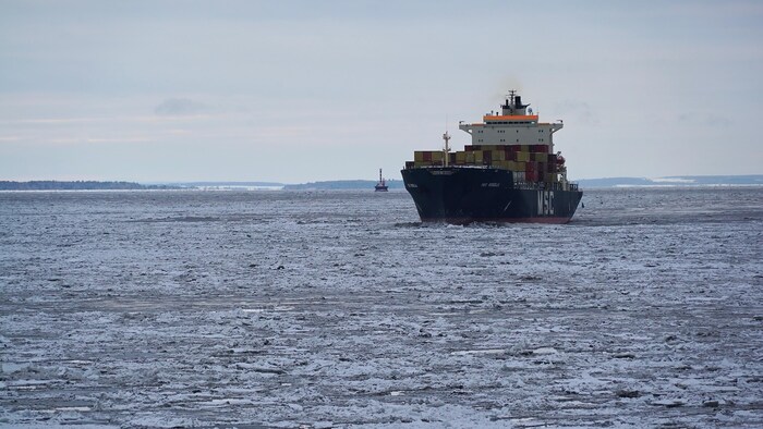 Un porte-conteneurs navigue à travers les glaces sur le fleuve Saint-Laurent.