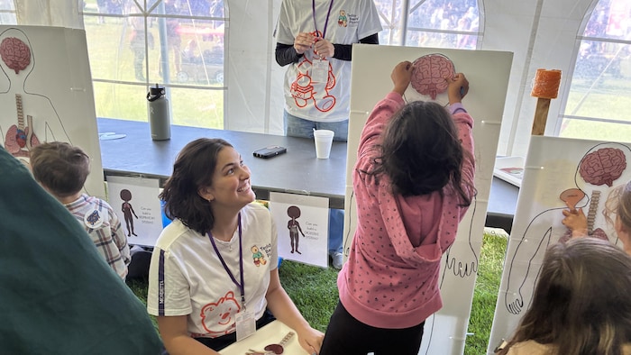 Des enfants participent à l'activité "Je veux être scientifique" au pique-nique Teddy Bear.